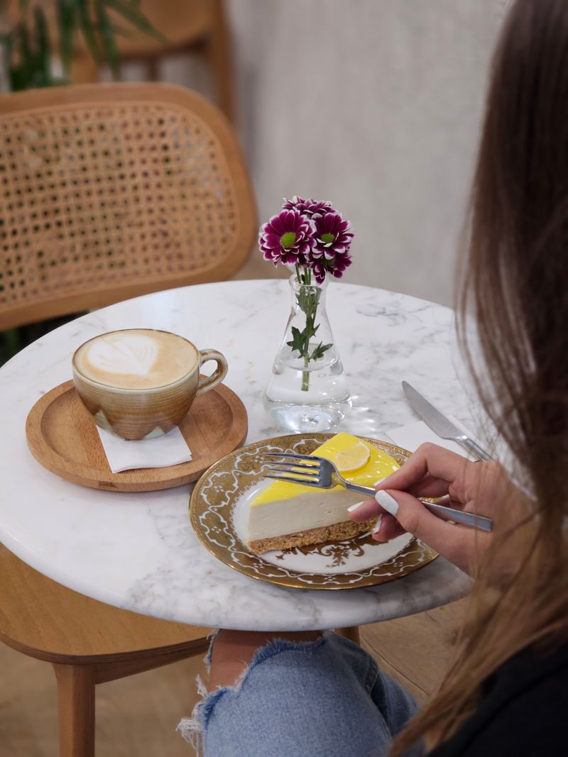 Cappuccino und ein Stück Zitronen-Käsekuchen auf einem Marmortisch