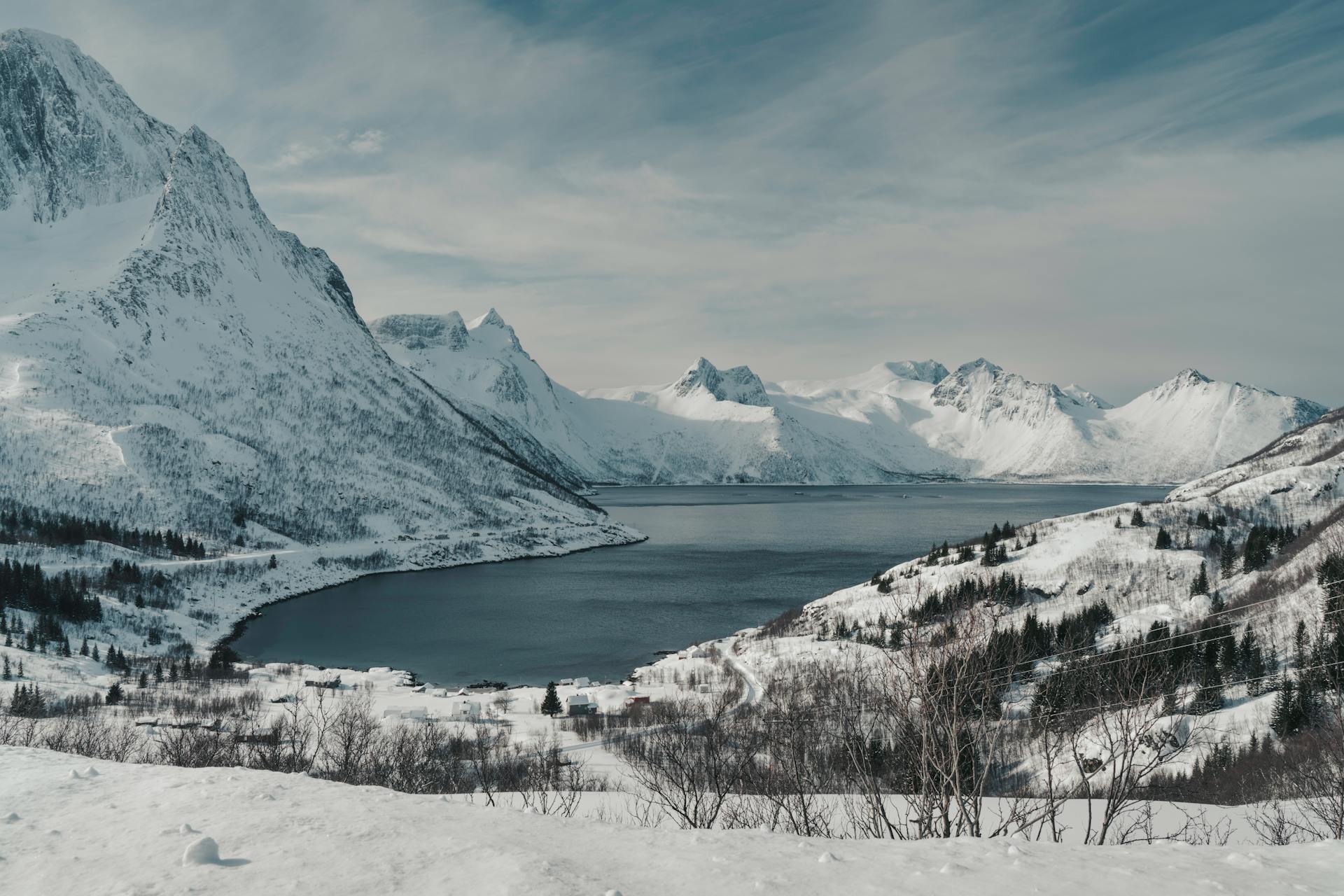 Stunning view of snow-capped mountains and fjord in Norway during winter season.