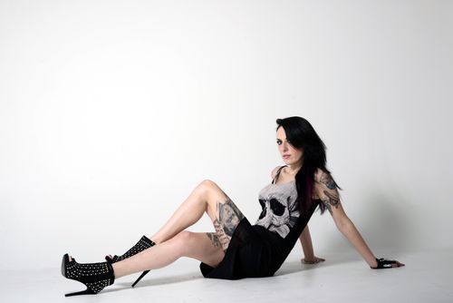 Free Edgy portrait of a tattooed woman in high heels and skull tank top. Stock Photo