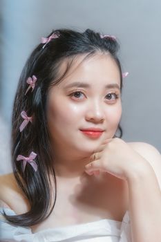 A soft-focus portrait capturing a woman with delicate ribbon hair accessories, exuding grace.