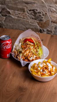Mouthwatering doner kebab with fries and a refreshing cola, perfect for a satisfying meal.