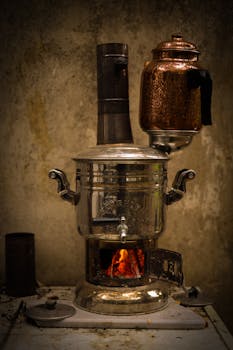 A rustic samovar with a copper tea kettle brewing over fire for authentic tea preparation.