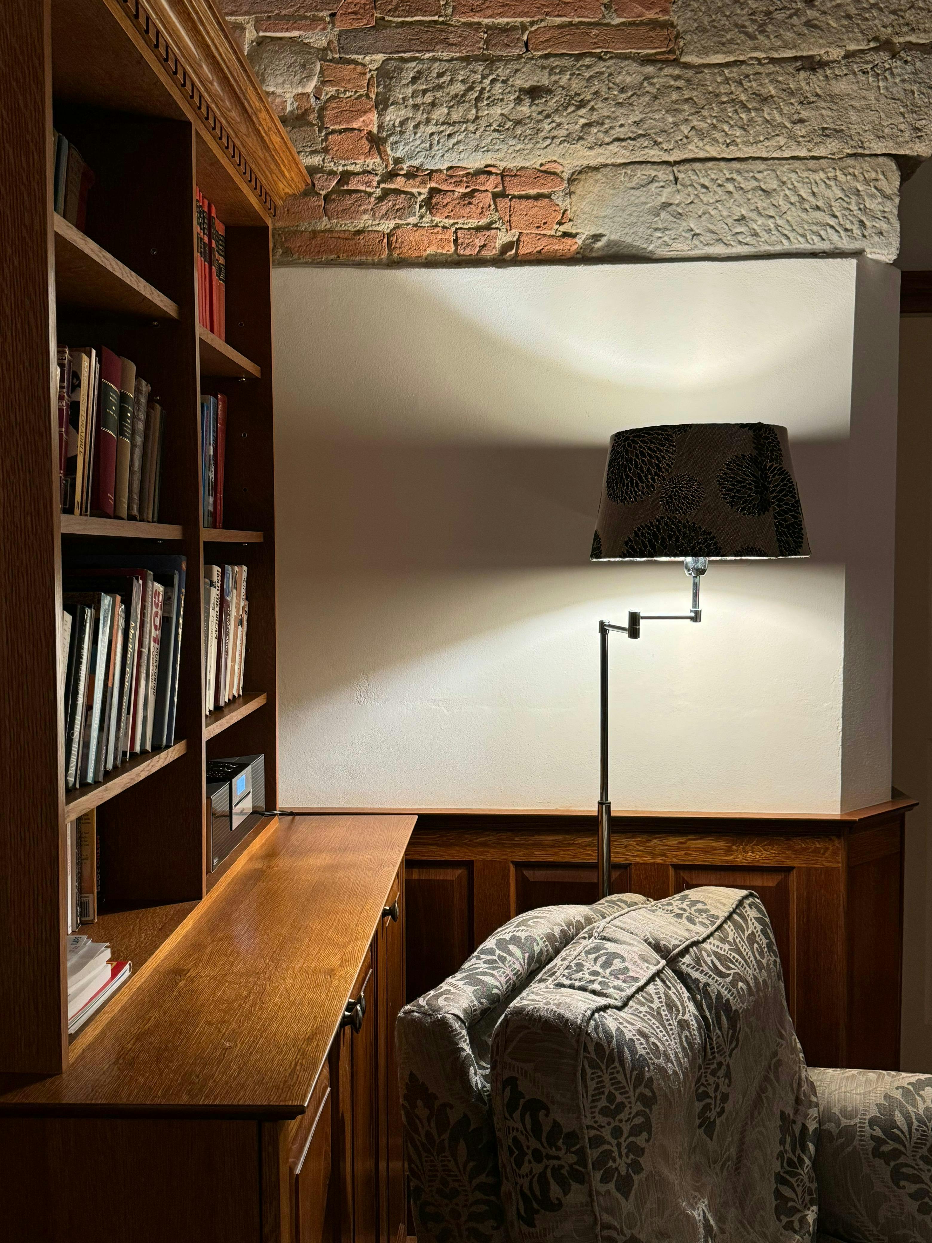 Gratuit Un colț de lectură liniștit cu rafturi din lemn și o lampă de epocă în Colleoli, Toscana. Fotografie de stoc