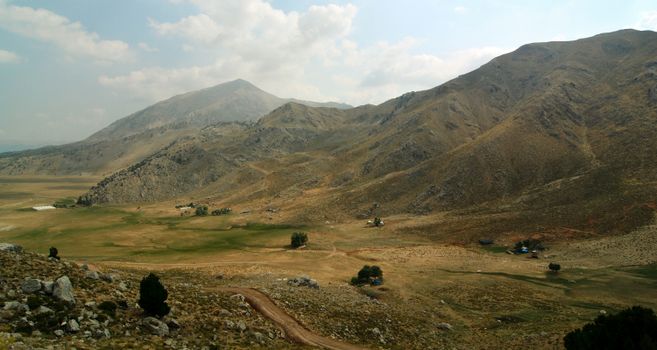 Explore the stunning mountainous landscape of Elmalı, Antalya with rocky terrains and grassy plateaus.