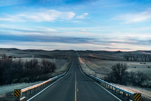 Free Straight road through prairie with wide open sky, creating a sense of freedom and exploration. Stock Photo