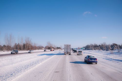 Free Cars and trucks driving on a snowy highway during winter daytime. Stock Photo
