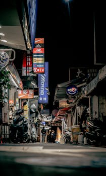 Explore the lively night scene with vibrant neon signs in a bustling Taipei street market.