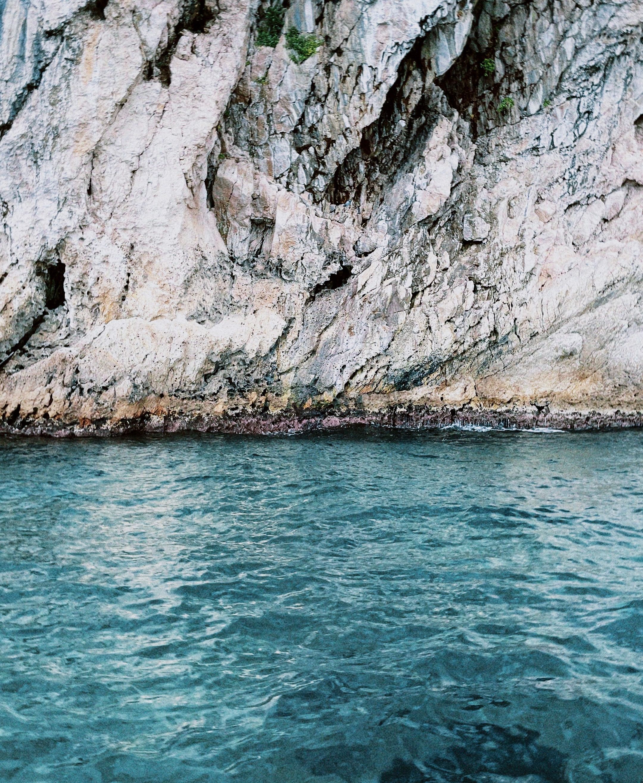 Scenic Rocky Coastal Cliff with Turquoise Waters · Free Stock Photo