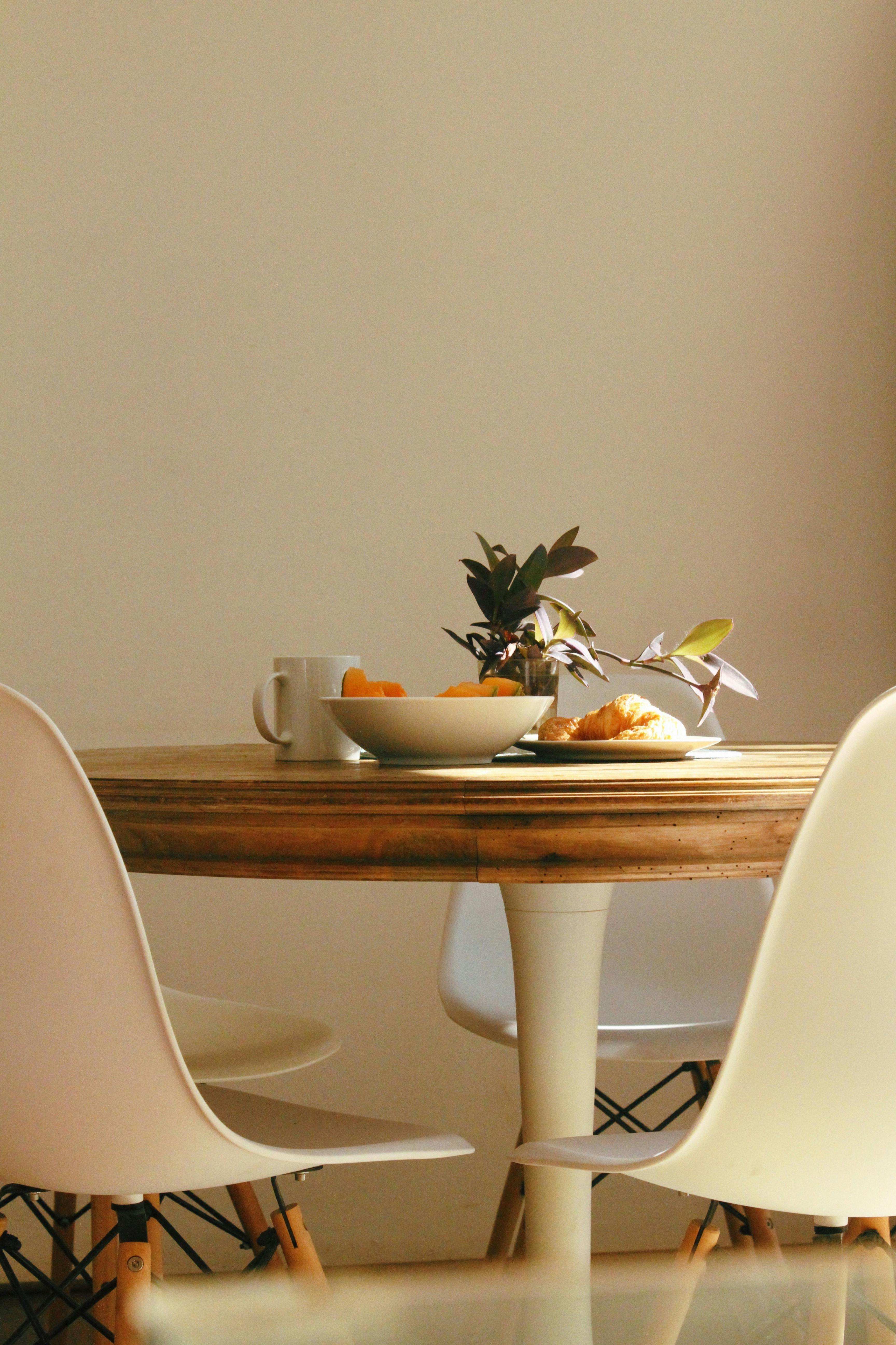 croissant bread beside bowl and mug on table