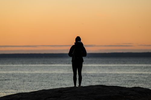Free A contemplative silhouette of a person at twilight on Stamford shoreline, capturing serene coastal views. Stock Photo