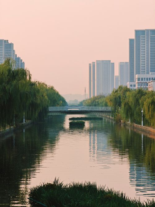 Free Peaceful urban scene with skyscrapers reflecting in a tranquil canal. Stock Photo