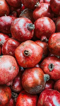 A vibrant collection of fresh red pomegranates showcasing their natural texture and color.