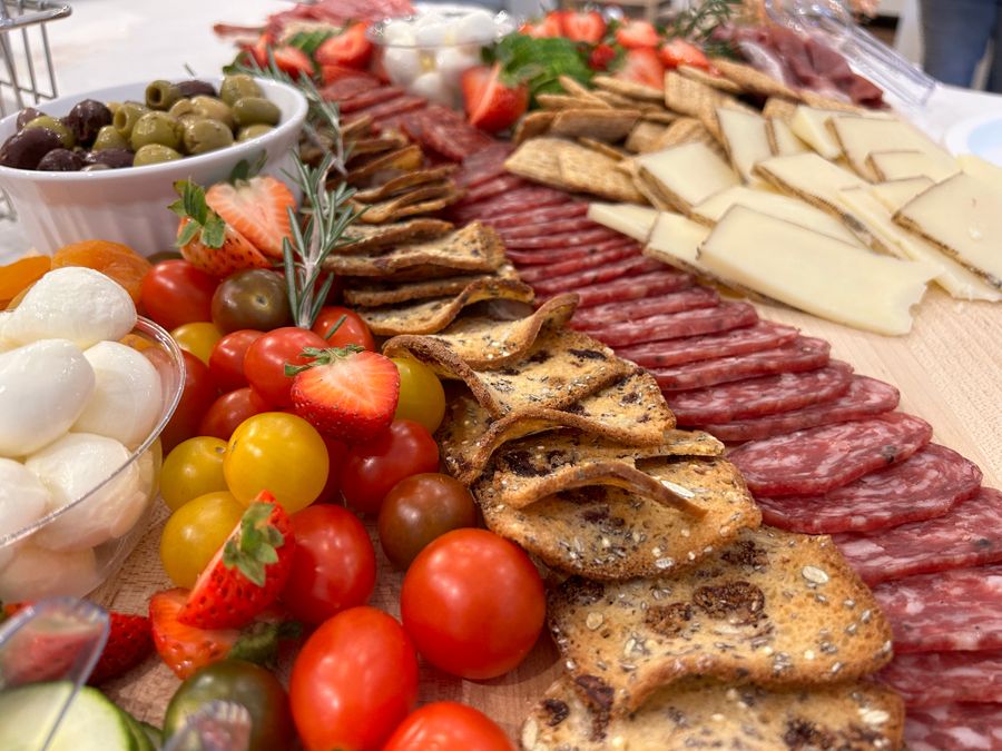 Tagliere colorato con formaggi, salumi e frutta fresca
