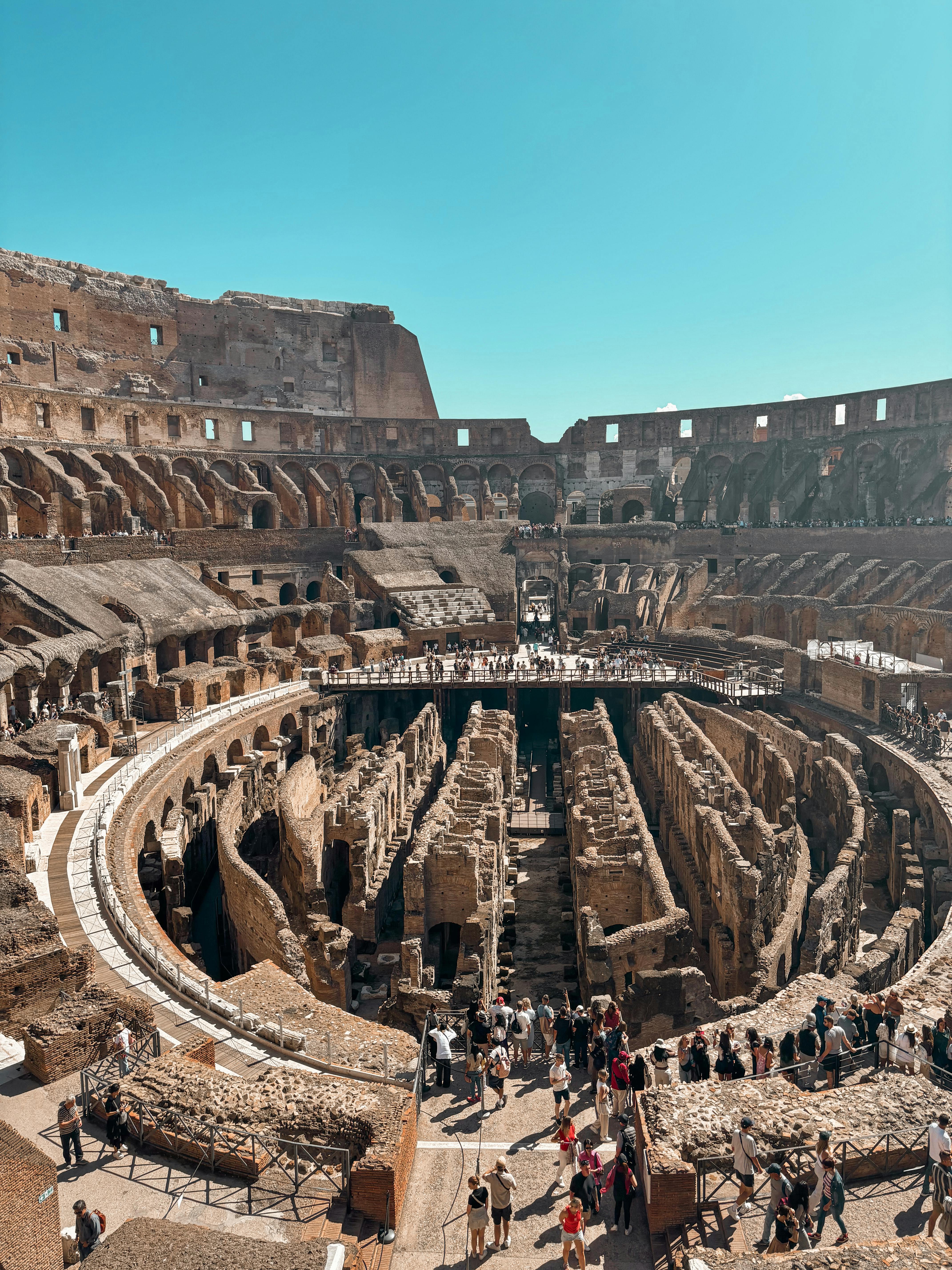 Ücretsiz Roma'daki antik Kolezyum'un muhteşem gündüz manzarası ve tarihi mekanı keşfeden turistler. Stok Fotoğraflar