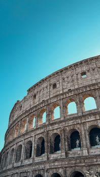 Stunning view of the ancient Roman Colosseum against a vibrant blue sky.