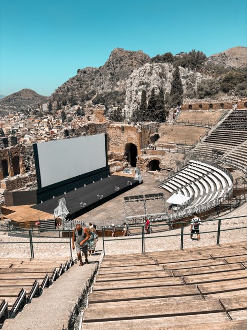 Free Ancient Greek theater in Sicily with a modern screen setup, blending history and technology. Stock Photo