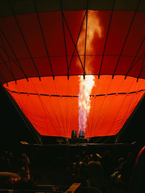Free A stunning view of a hot air balloon being inflated with fire at a nighttime festival. Stock Photo