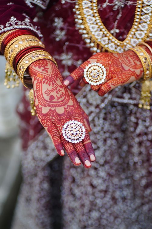Free Close-up of intricate henna designs on bride's hands adorned with jewelry during a traditional wedding ceremony. Stock Photo