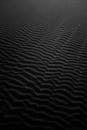 黑色沙子上展示着抽象单色图像的复杂波纹图案