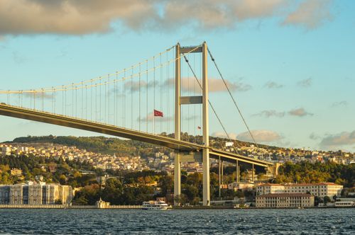Free View of the Bosphorus Bridge crossing over Istanbul's vibrant cityscape with clear skies. Stock Photo