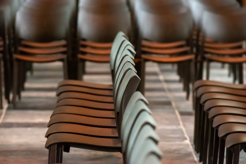 Close-up view of rows of stacked chairs in an indoor venue, ensuring neatness.