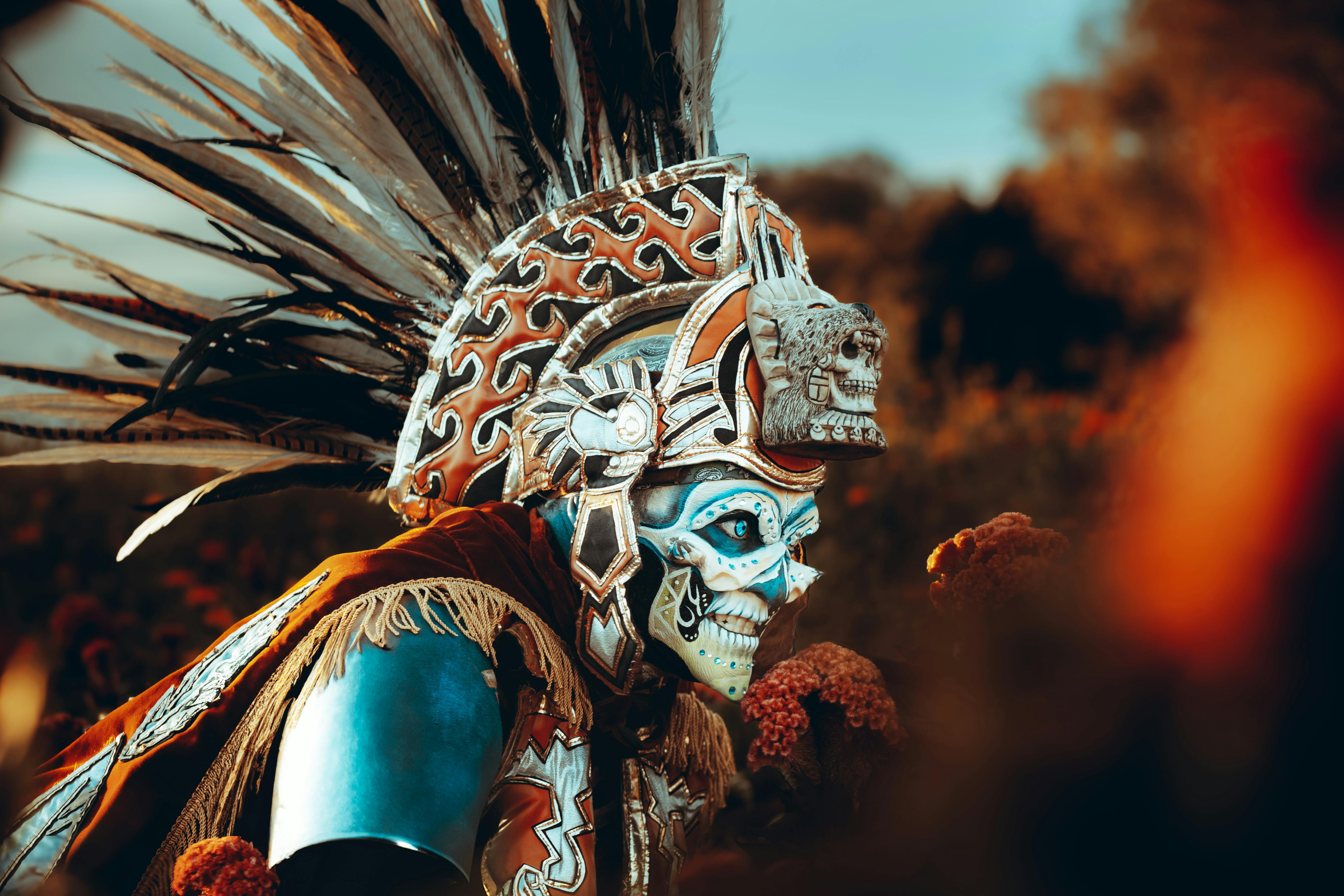 Aztec warrior in vibrant traditional attire with feathered headdress in Cholula, Mexico.