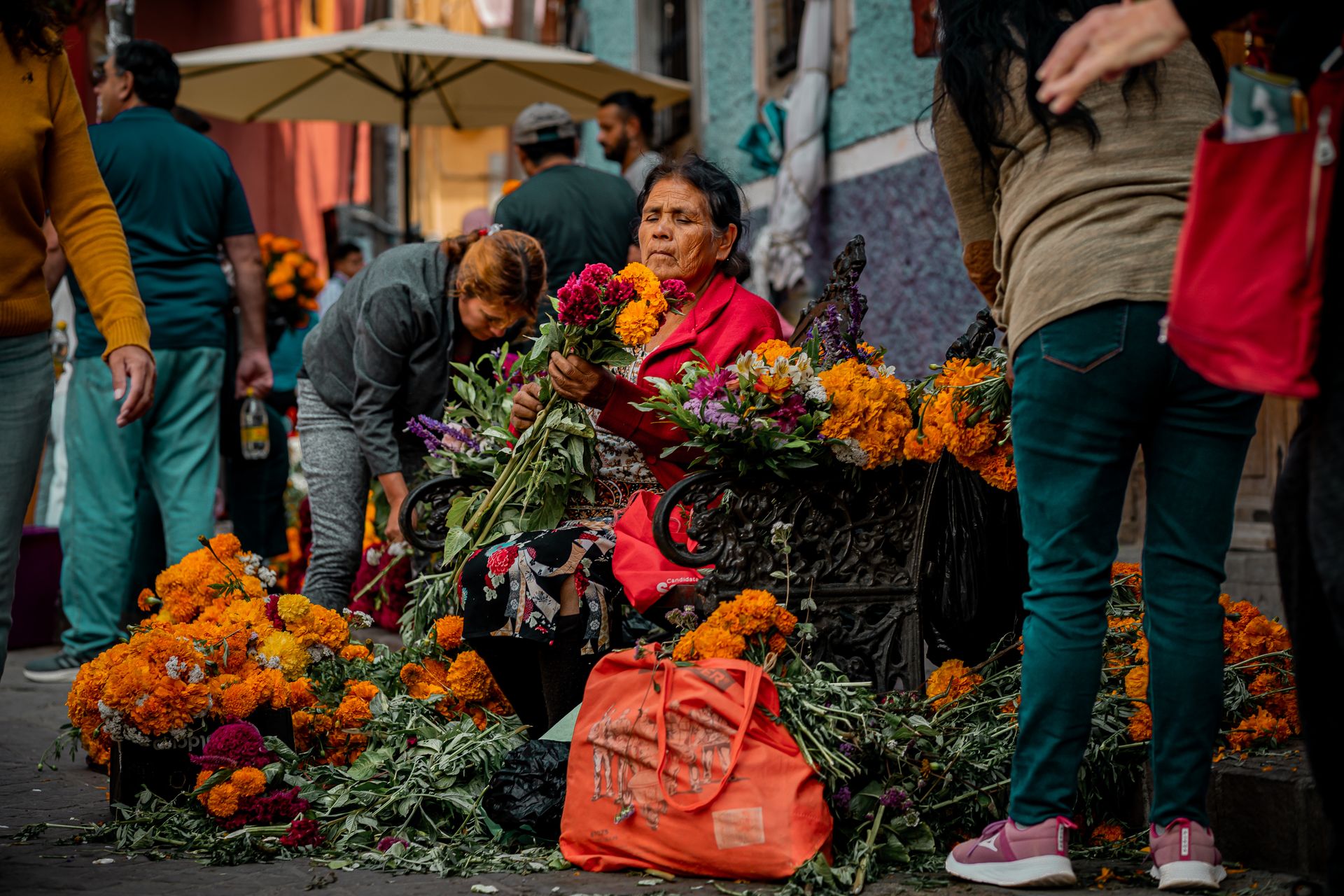 Indigenous woman selling vibrant cempasuchil flowers during Day of the Dead in Guanajuato, Mexico.