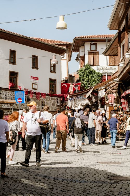 Free People strolling through a busy market street in Ankara, Turkey, with shops and Turkish flags visible. Stock Photo