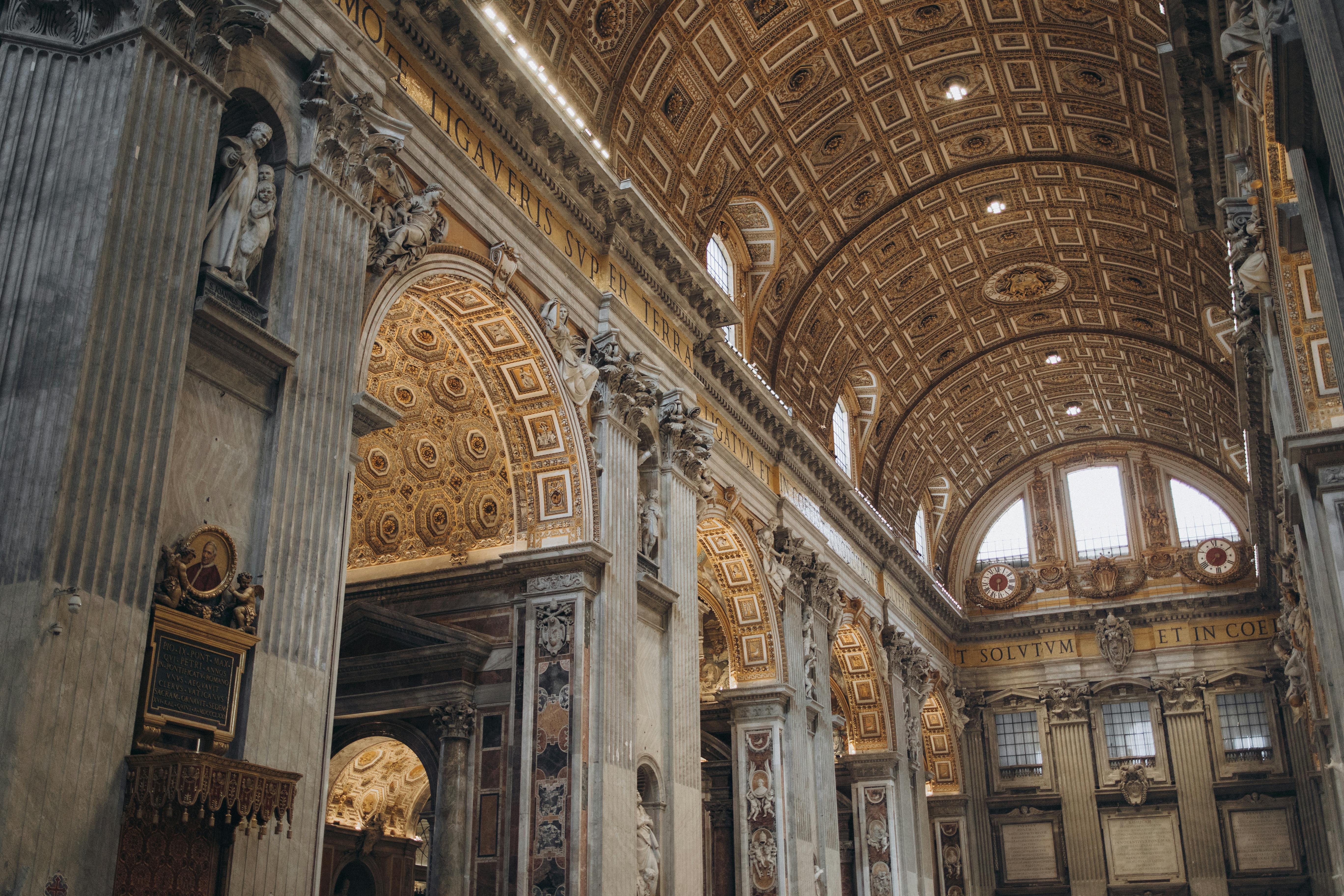 бесплатная Внутренний вид собора Святого Петра, демонстрирующий витиеватые детали и величественную архитектуру Ватикана. Стоковое фото