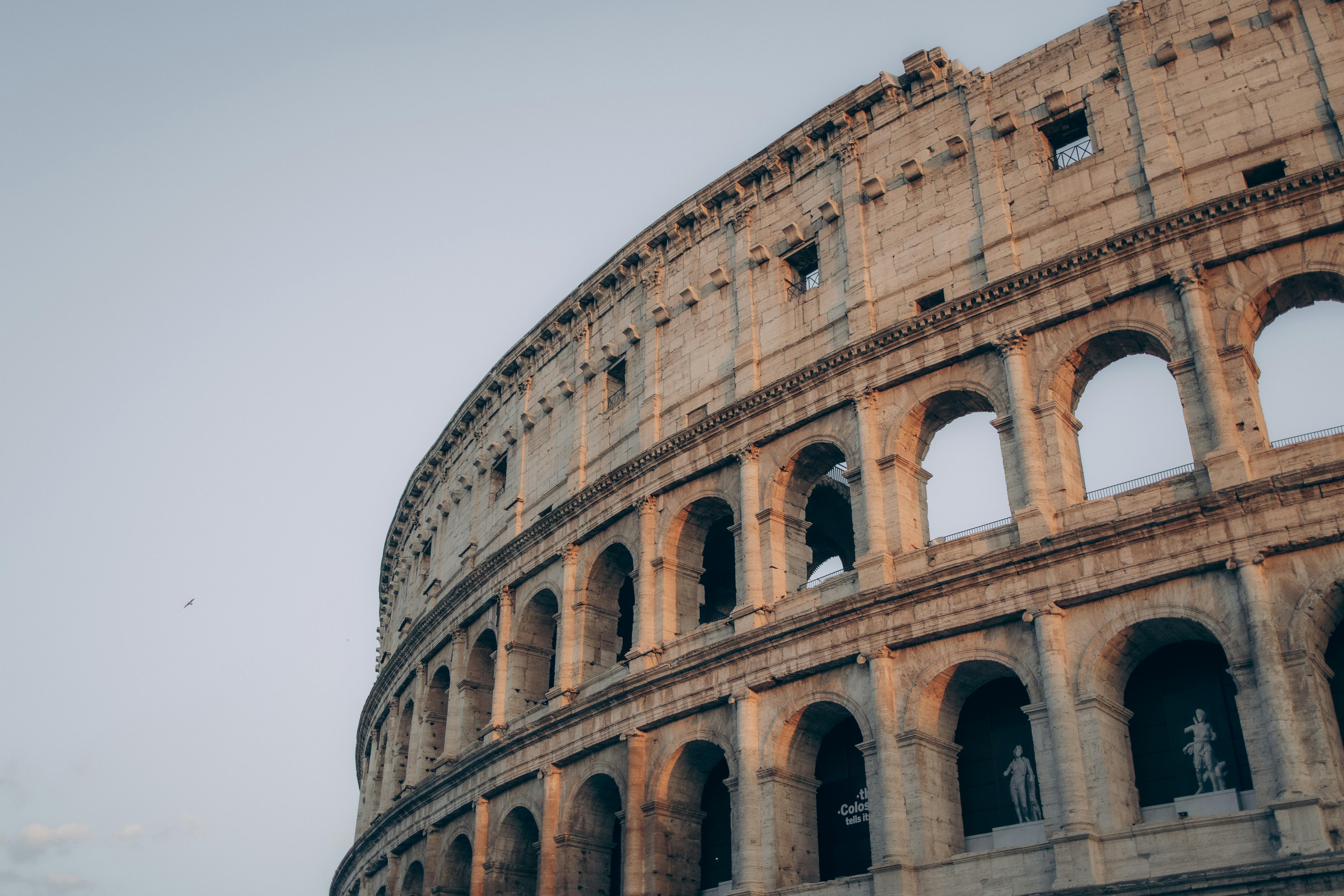 Ilmainen Kuvaus ikonisesta Colosseumista Roomassa, Italiassa auringonlaskun aikaan ja esittelee sen muinaista arkkitehtuuria. Kuvapankkikuva