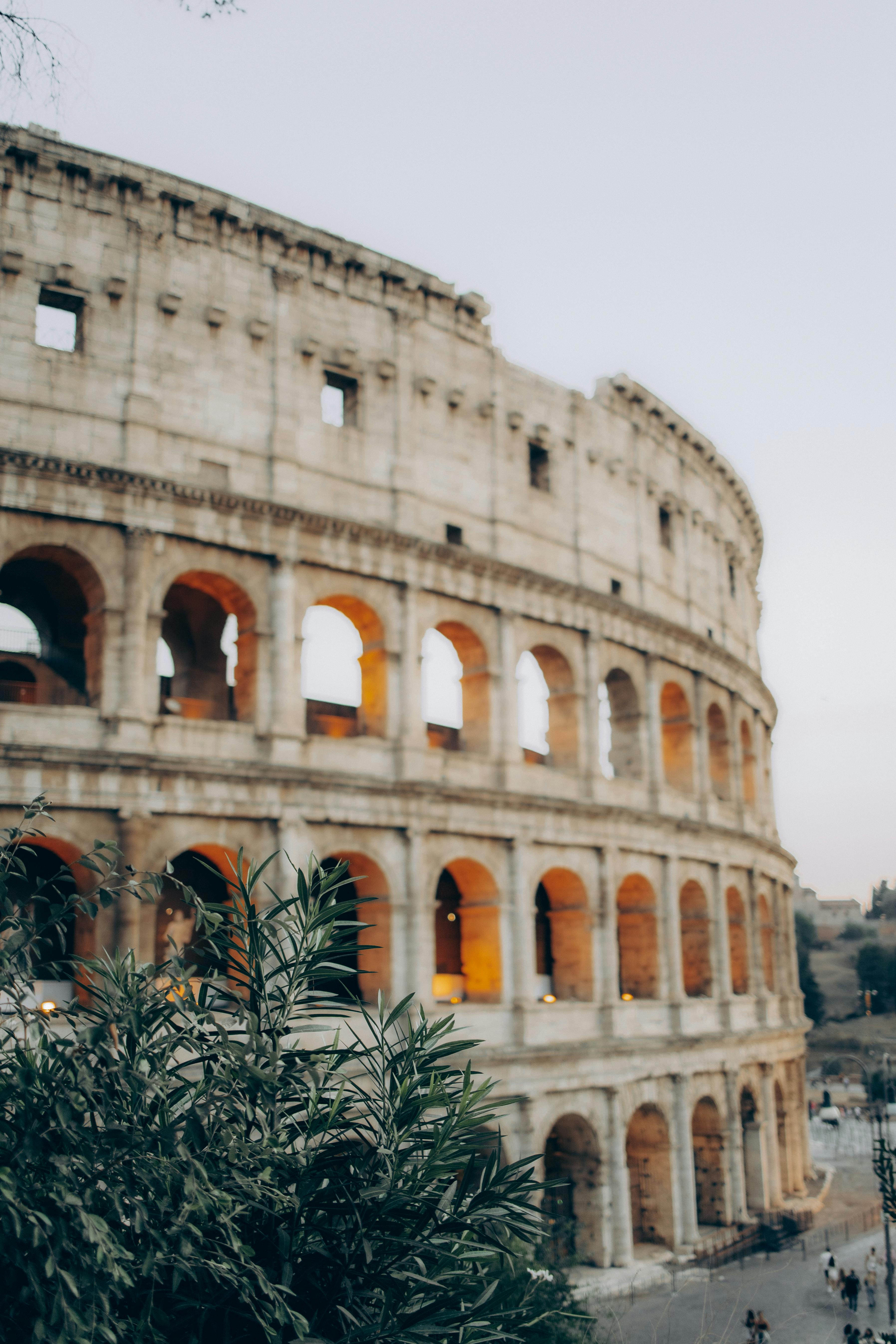 A stunning view of Rome's Colosseum lit up at dusk, showcasing its ancient architecture.