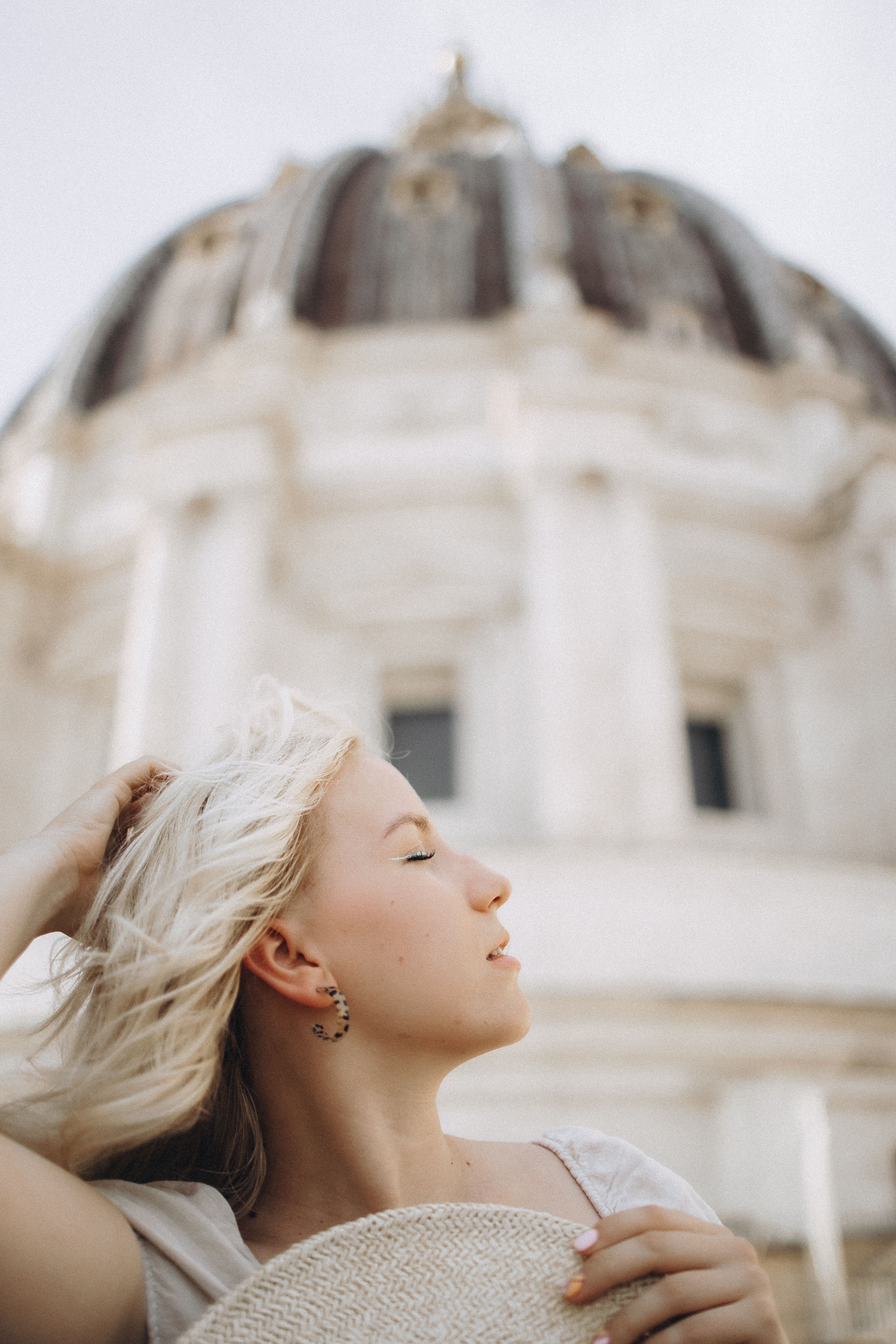 Woman enjoying outdoor breeze in front of St. Peter's Basilica in Vatican City.