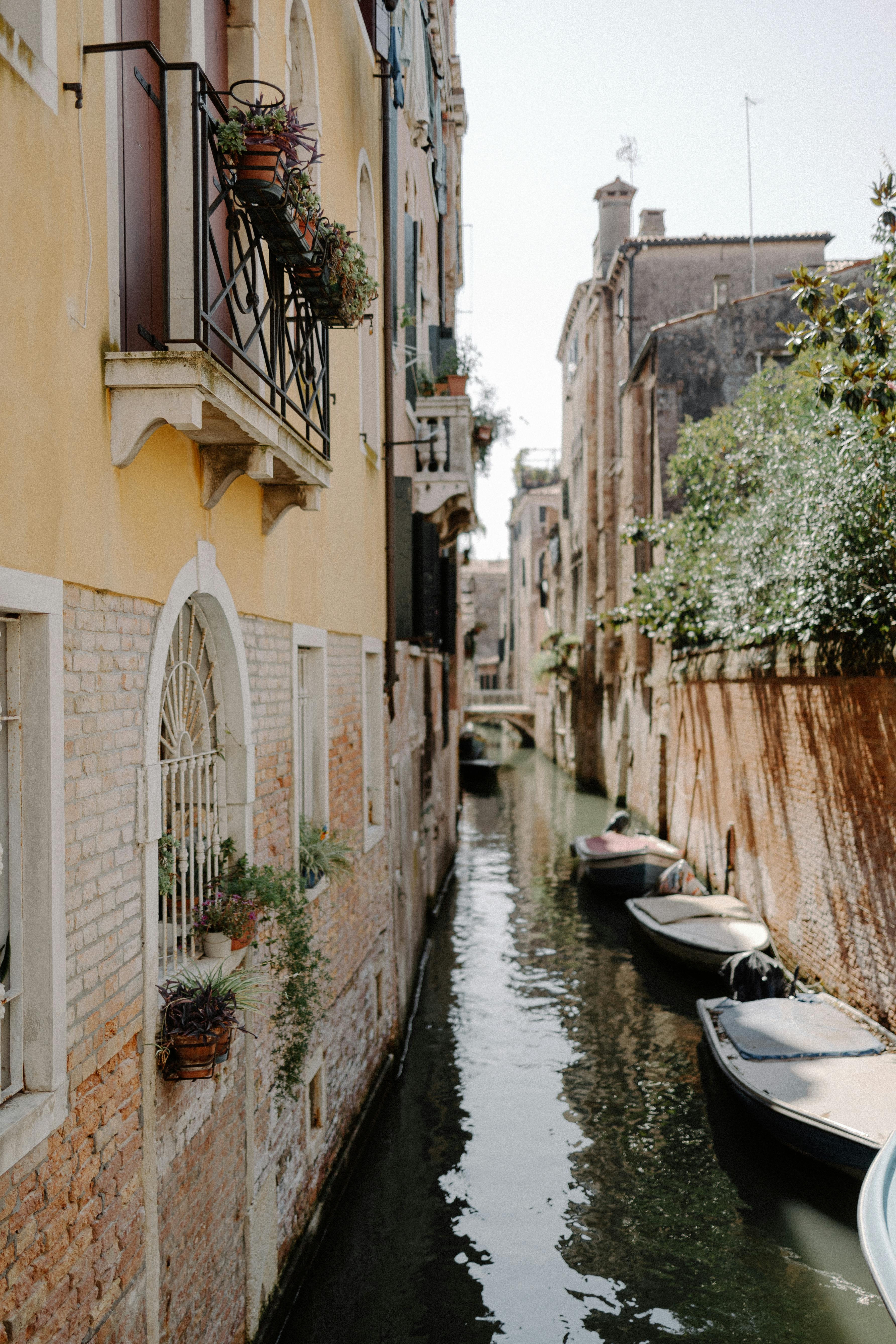 Serene canal view in Venice with boats and traditional balconies on a sunny day.