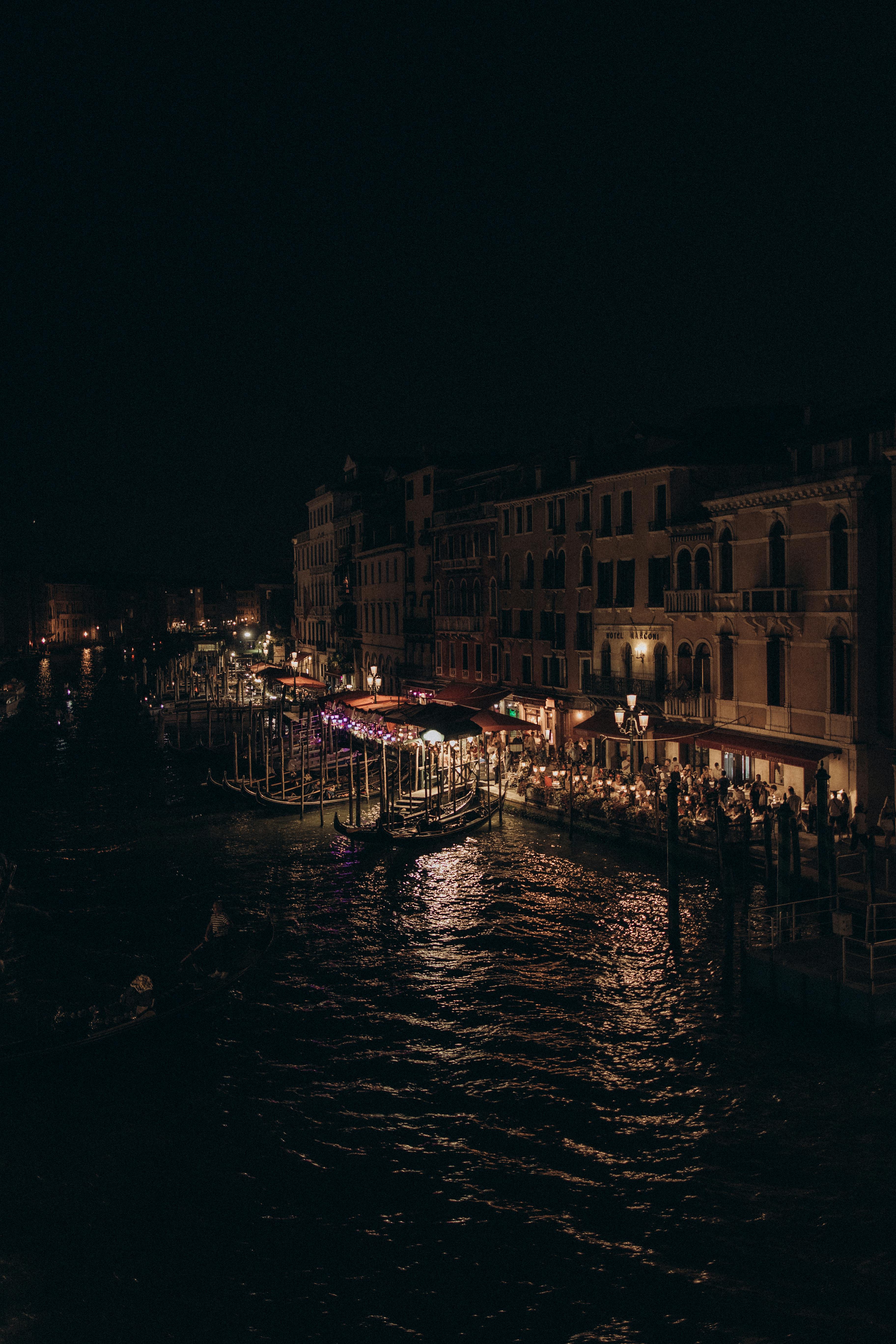 Atmospheric night view of Venice's Grand Canal with illuminated buildings and gondolas.