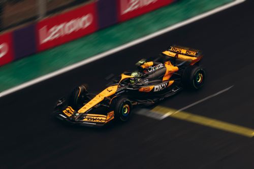 Free Dynamic shot of a Formula 1 car speeding on a race track during daytime. Stock Photo