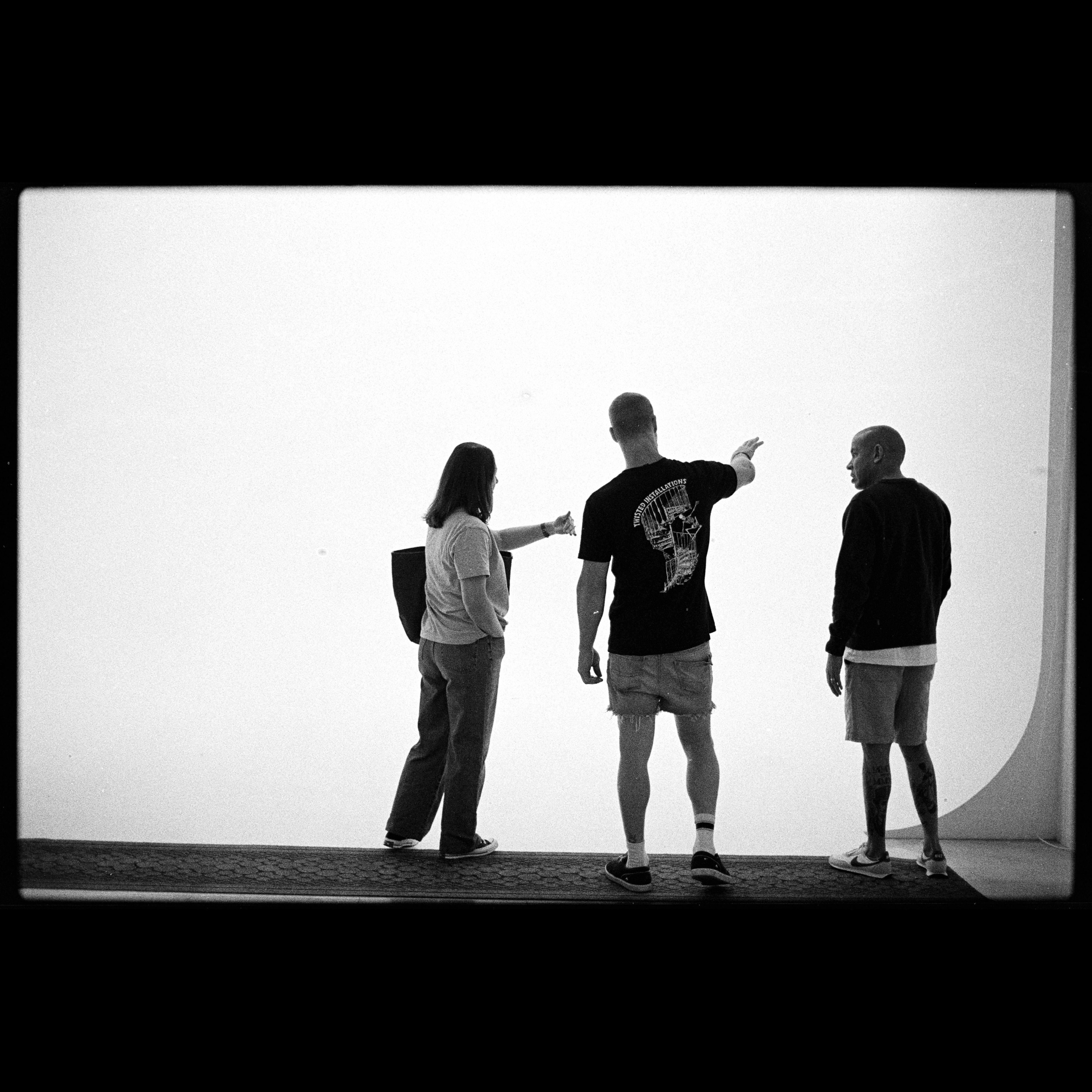 Silhouettes of a group discussing in black and white against a stark white background.