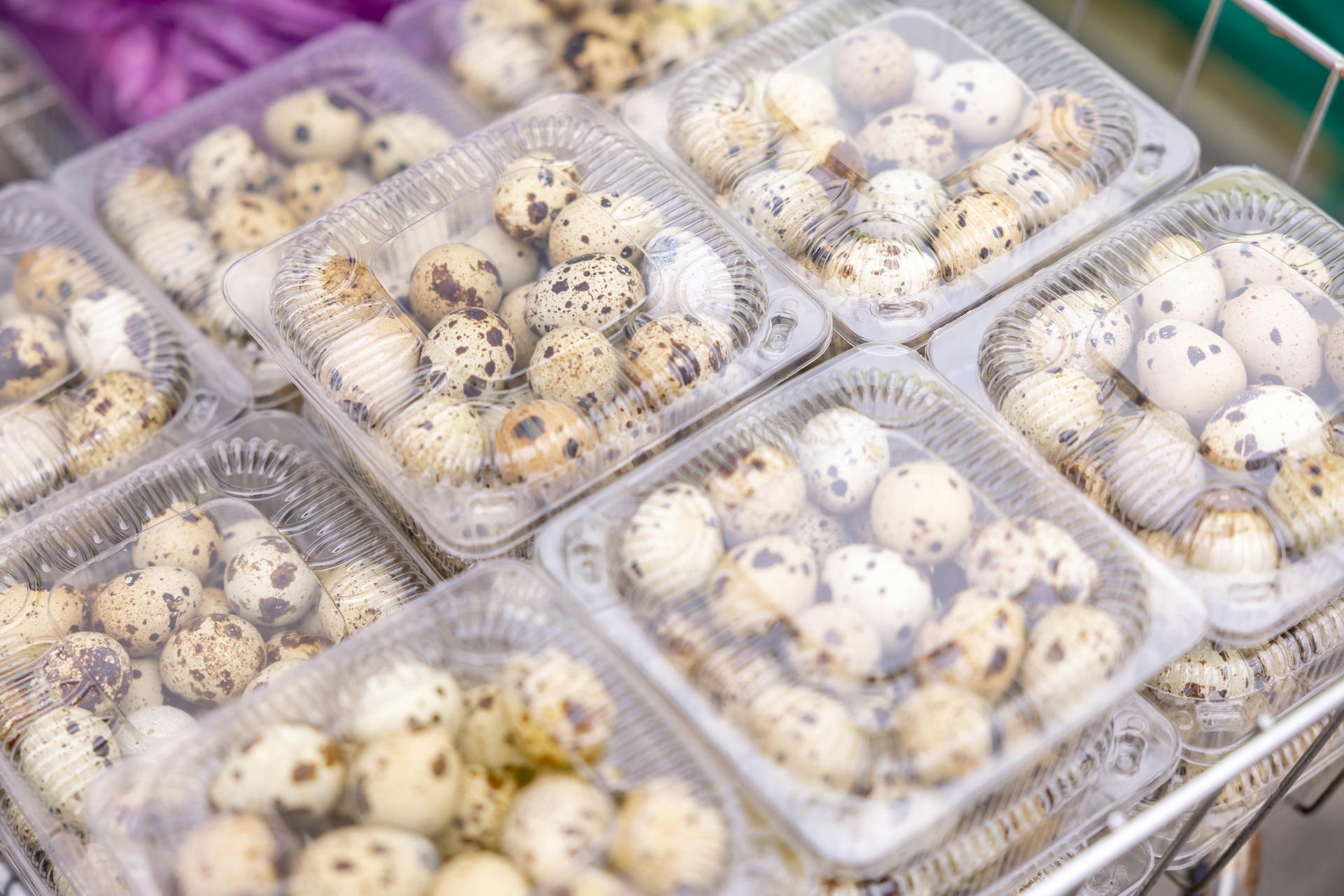 Quail eggs in transparent plastic packaging at a market. Ideal for culinary and food industry themes.