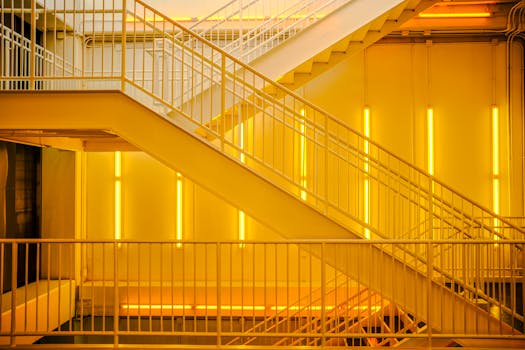 A contemporary staircase with bright yellow neon lights creating an industrial ambiance.