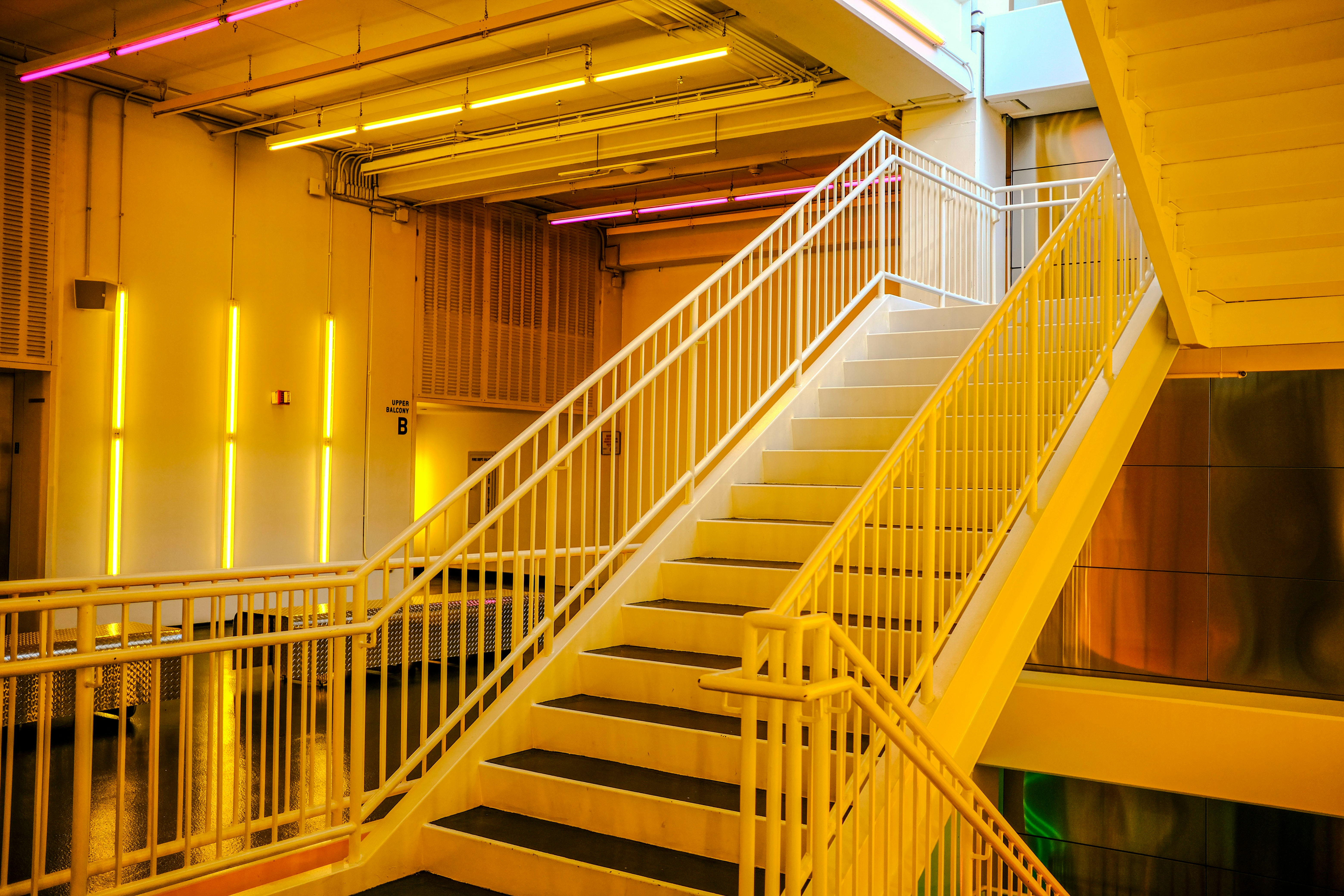 Vibrant stairway with neon lighting in a contemporary building interior.