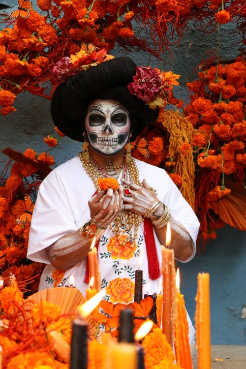 Free Skull makeup and marigold flowers highlight a vibrant Day of the Dead celebration. Stock Photo