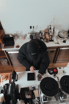 Top-down view of a barista crafting coffee in a modern, minimalistic cafe setting.