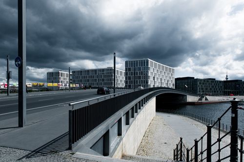 Free A dramatic view of modern office buildings and bridge under a cloudy sky in Berlin, Germany. Stock Photo