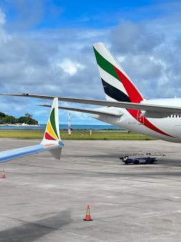 A vibrant scene at Seychelles Airport featuring aircraft tails with clear skies and ocean view.