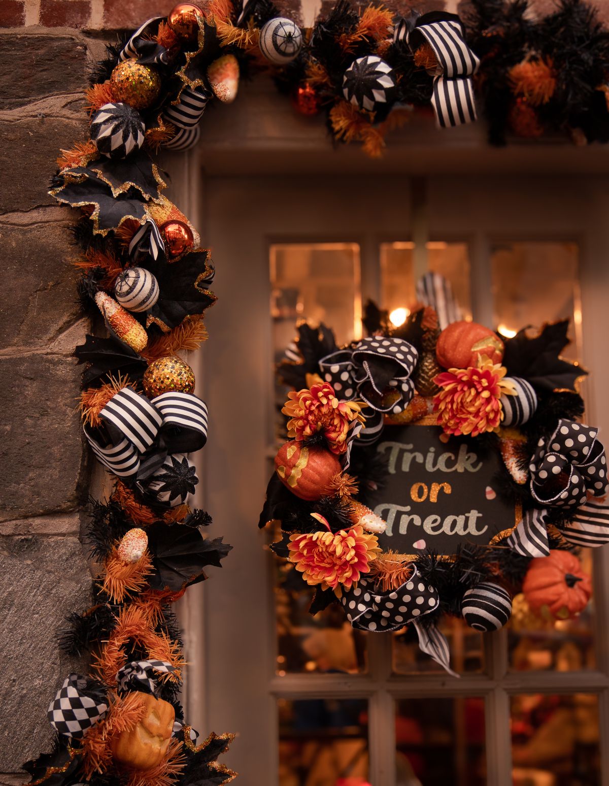 Halloween wreath with a Trick or Treat sign hanging on a front door