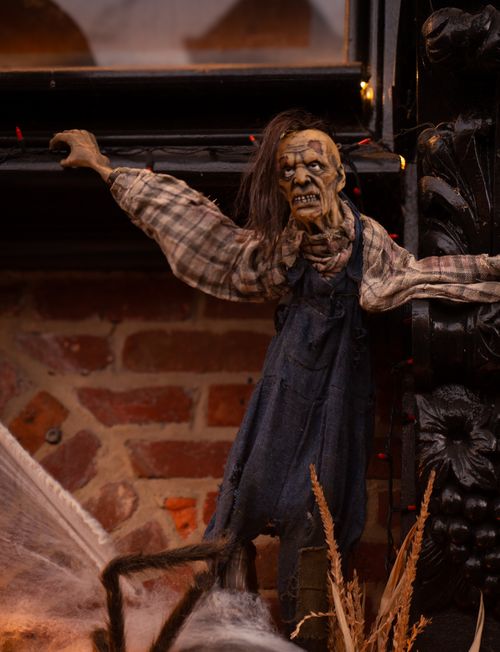 Gratuit Une marionnette effrayante vêtue d'une salopette à carreaux et en jean sur un mur de briques, parfaite pour la décoration d'Halloween. Photos