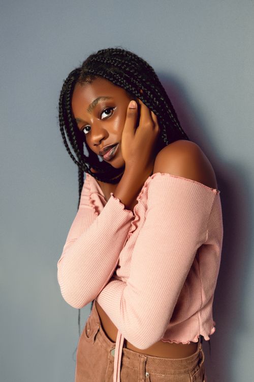 Free Stylish portrait of a young woman in a pink top against a neutral background. Stock Photo