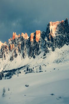 Capture of the majestic Dolomites with snow-covered peaks and dramatic lighting.
