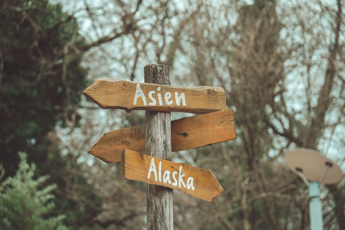 Rustic wooden directional signposts pointing in opposite directions in an outdoor setting