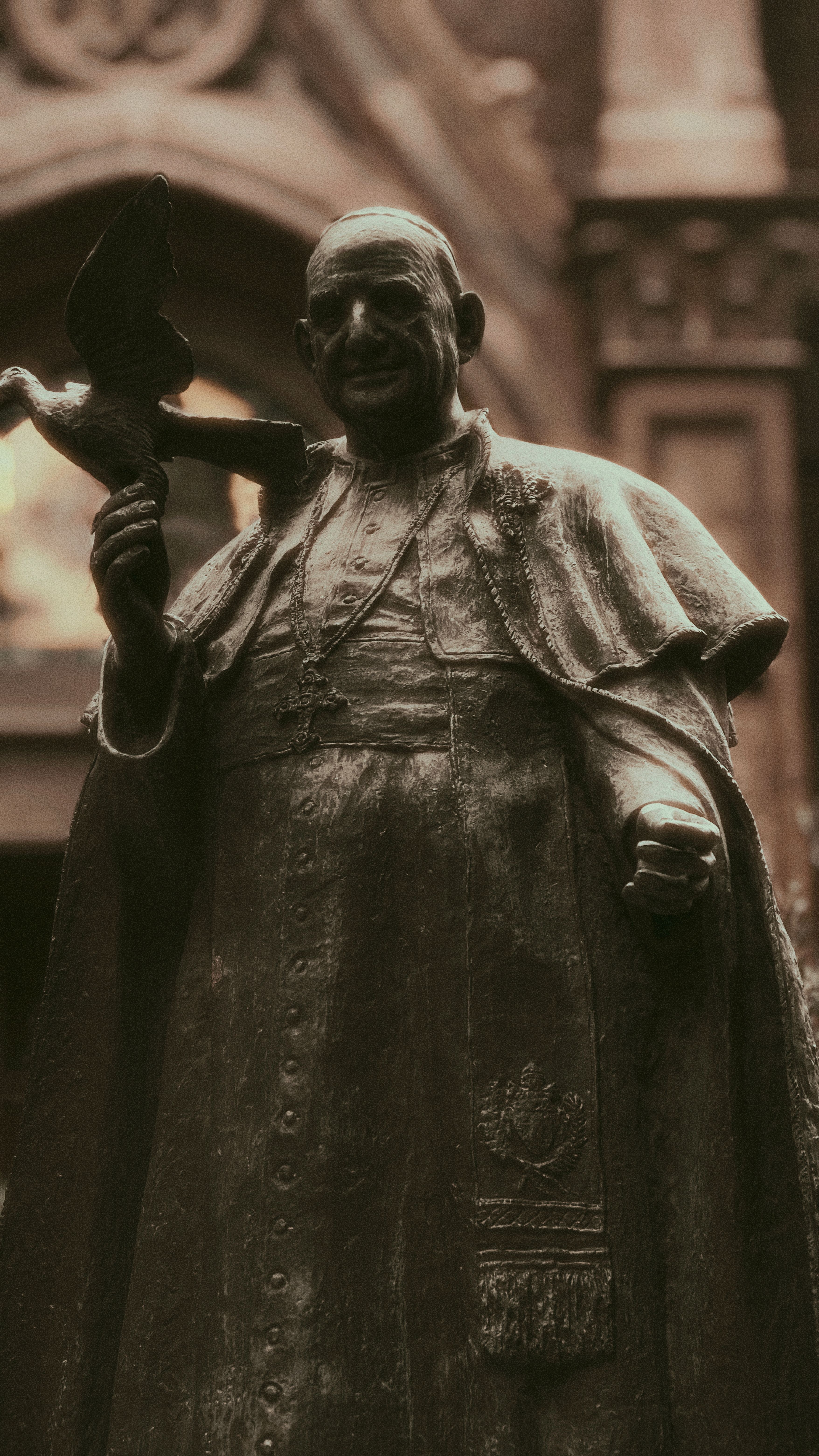 Bronze statue of a religious figure holding a dove, located outdoors in Istanbul.