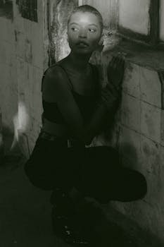 这幅时尚的单色肖像描绘了一位在城市环境中摆姿的女性，展现了现代时尚